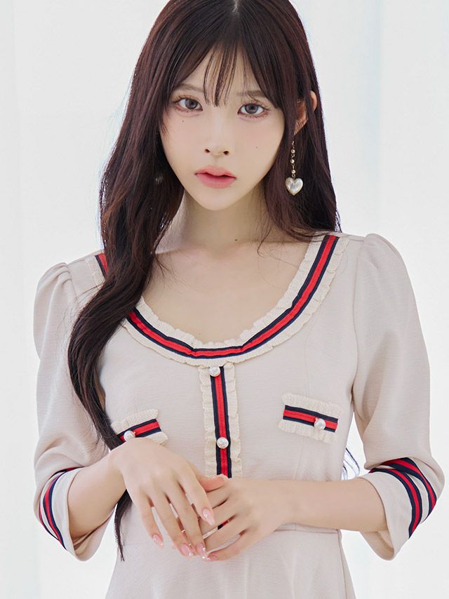 アイボリーのパフスリーブと異素材ラインがアクセントになった、上品なフレアミニドレス。